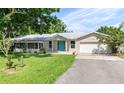 Single story house with teal front door, attached garage, and large yard at 8516 Riverside Dr, Punta Gorda, FL 33982
