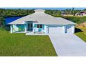 Newly built waterfront home with light blue exterior and a two-car garage at 2239 Cornelius Blvd, Port Charlotte, FL 33953