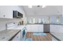 Modern kitchen with white cabinets, stainless steel appliances, and wood-look flooring at 7456 Jennifer Dr, Port Charlotte, FL 33981