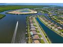 Stunning aerial view of a waterfront community with canals, lush greenery, and a boat speeding along at 15240 Spanish Point Dr, Port Charlotte, FL 33981