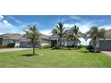 Lovely single-story home with a spacious lawn, mature landscaping, and a three-car garage at 15240 Spanish Point Dr, Port Charlotte, FL 33981