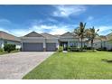 Beautiful single-story home with a tile roof, three-car garage, and lush landscaping at 15240 Spanish Point Dr, Port Charlotte, FL 33981