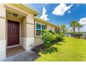 Well-maintained house exterior, featuring a brown door and manicured lawn at 8883 Tuscany Isles Dr, Punta Gorda, FL 33950
