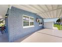 Covered patio with brick walls, and access to a backyard and storage shed at 8724 Agress Ave, North Port, FL 34287