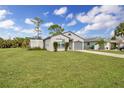House with a large green yard and driveway at 481 Ricold Ter, Port Charlotte, FL 33954