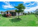 Spacious backyard with screened patio and lush landscaping at 43614 Sparrow Dr, Punta Gorda, FL 33982
