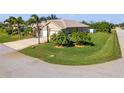 Single-story home with three-car garage, palm trees, and well-manicured lawn at 14176 Saul Ln, Port Charlotte, FL 33981