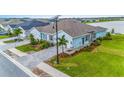 Desirable home in a peaceful community featuring lovely landscaping, a brick driveway, and a picturesque lake view at 1781 W Palms Dr, Port Charlotte, FL 33953