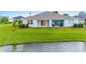 Single-story home with covered patio and lake access at 1781 W Palms Dr, Port Charlotte, FL 33953