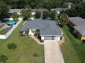 House with a grey roof, white fence, and a paved driveway, aerial view at 3721 Monday Ter, North Port, FL 34286
