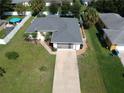 Single story house with grey roof, paved driveway and a fenced-in backyard at 3721 Monday Ter, North Port, FL 34286