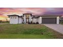 Stunning curb appeal with a two-car garage and beautiful landscaping at sunset at 13493 Los Angeles Ave, Port Charlotte, FL 33981