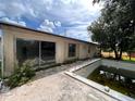 Needs renovation. In-ground pool with surrounding patio at 21098 Glendale Ave, Port Charlotte, FL 33952