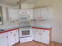 Bright kitchen features white cabinets, red countertops, and a built-in microwave at 5787 Holiday Park Blvd, North Port, FL 34287