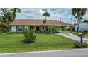 Charming single-story home featuring a brick-accented facade, manicured lawn, and a covered carport at 2256 Auburn Blvd, Port Charlotte, FL 33948