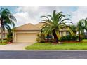 One-story house with tile roof, palm trees and two-car garage at 6913 Talon Bay Dr, North Port, FL 34287