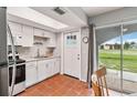 Bright kitchen features white cabinets, stainless steel appliances, and tile floors at 108 Boundary Blvd # A&B, Rotonda West, FL 33947