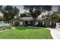 One-story house with a brown exterior, manicured lawn, and a paved driveway at 182 Monica St, Port Charlotte, FL 33954