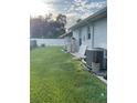 Backyard with grassy area, AC unit, and water softener at 2106 Switzerland Rd, North Port, FL 34288