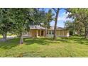 Single-story home with light yellow exterior and large green lawn at 791 Haleybury St, Port Charlotte, FL 33948