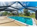 A stunning in-ground pool is enclosed within a screened-in lanai, offering privacy and protection from the elements at 258 Shadow Nw St, Port Charlotte, FL 33952