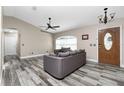 Living room with gray sofas, wood-look floors, and a view of the front door at 3159 Draper Ter, North Port, FL 34286