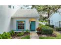 White condo with teal door and landscaping at 6568 Fairway Gardens Dr, Bradenton, FL 34203