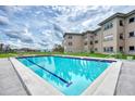 Outdoor swimming pool and condo building on a sunny day with blue skies and fluffy white clouds at 3100 Harbor Blvd # 116, Port Charlotte, FL 33952