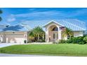 Tan house with metal roof, double door entry, and palm trees at 7369 Schefflera, Punta Gorda, FL 33955