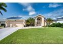 Tan house with metal roof, double door entry, and palm trees at 7369 Schefflera, Punta Gorda, FL 33955