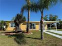 Bright yellow house with landscaping and palm trees at 21938 Catherine Ave, Port Charlotte, FL 33952