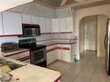 Kitchen with white cabinets, red accents, and appliances at 269 Rosemary St, Port Charlotte, FL 33954