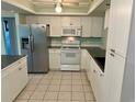 Kitchen with white cabinets, stainless steel appliances, and tile floor at 512 Chamber Nw St, Port Charlotte, FL 33948