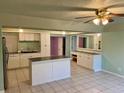 Kitchen features island, white cabinets, and tile flooring at 512 Chamber Nw St, Port Charlotte, FL 33948