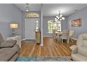 Bright dining room featuring hardwood floors and elegant light fixture at 24703 Buckingham Way, Punta Gorda, FL 33980