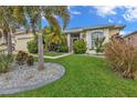 Single-story home with landscaping and palm trees at 24703 Buckingham Way, Punta Gorda, FL 33980