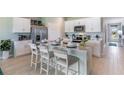 Modern kitchen with white cabinets, center island, stainless steel appliances, and teal accents at 18096 Windswept Ave, Port Charlotte, FL 33948