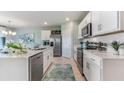 Modern kitchen with white cabinets, stainless steel appliances, and a spacious island at 18096 Windswept Ave, Port Charlotte, FL 33948