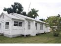 White house with side yard and mature trees at 702 W Olympia Ave, Punta Gorda, FL 33950