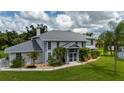 Two-story home with a screened entrance, well-kept lawn and landscaping, and a stately chimney at 196 Lecturn St, Port Charlotte, FL 33954