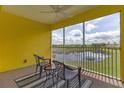 Lanai with lake view, ceiling fan, and seating for two at 2140 Heron Lake Dr # 308, Punta Gorda, FL 33983