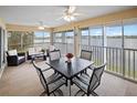 Bright sunroom with lake view, table, chairs, and comfortable seating at 26283 Nadir Rd # 201, Punta Gorda, FL 33983