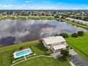 Aerial view showing condo, pool, and lake in the background at 26283 Nadir Rd # 201, Punta Gorda, FL 33983