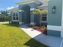 Inviting front entrance featuring a well-manicured lawn and a concrete walkway at 10133 Audrey St, Port Charlotte, FL 33981