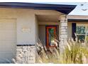 House entrance with orange door, stone pillars, and landscaping at 20280 Macon Ln, Port Charlotte, FL 33952