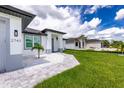 Newly built home with gray siding and paver driveway at 2743 Hopwood Rd, North Port, FL 34287