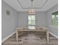 Dining room featuring wood-look tile, modern light fixture, and natural light from a window at 14516 San Domingo Blvd, Port Charlotte, FL 33981
