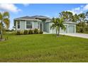 Charming single-story home featuring a three-car garage and lush green lawn at 14516 San Domingo Blvd, Port Charlotte, FL 33981