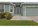 Inviting front entrance showcasing a well-kept garden and a charming exterior light fixture at 14516 San Domingo Blvd, Port Charlotte, FL 33981