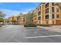 Condo building with Spanish-style architecture, ample parking, and landscaping at 95 Vivante Blvd # 9542, Punta Gorda, FL 33950